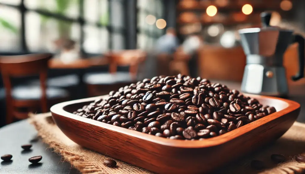 Freshly roasted dark roast coffee beans spread on a wooden tray