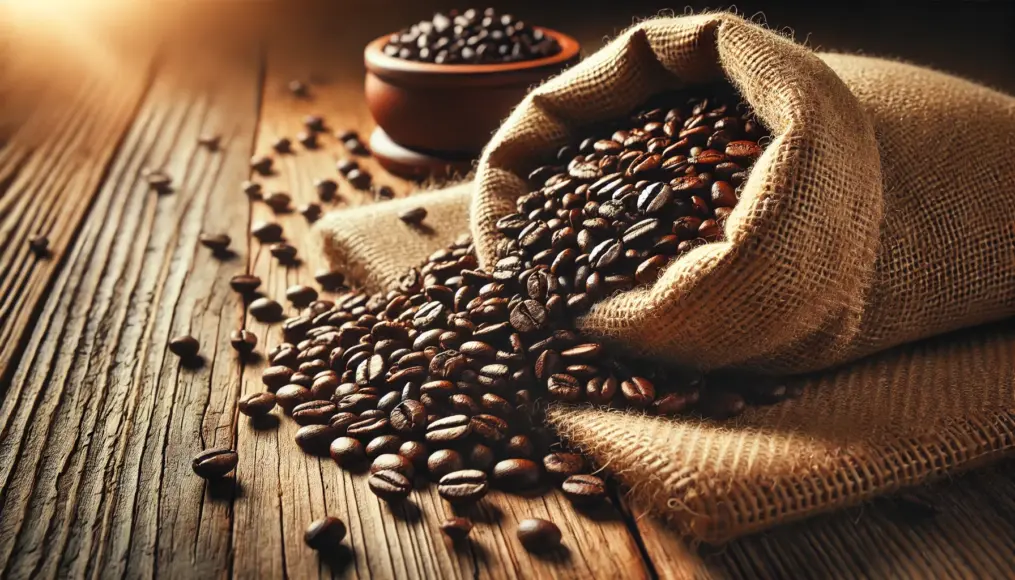 Dark roasted Mandheling coffee beans. Glossy black beans spill out from a burlap sack onto a wooden table.